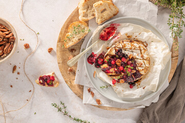 Baked or fried grilled Camembert or brie cheese with berry sauce or jam. Gourmet traditional...