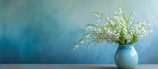 Foto auf Acrylglas White lily of the valley bouquet in a blue gradient vase. © TheWaterMeloonProjec