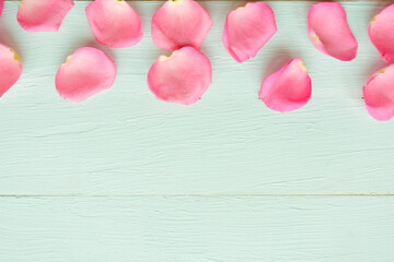 Pink rose petals on blue wooden background. Flat lay, top view, copy space. Valentine's Day or Wedding background. Love concept