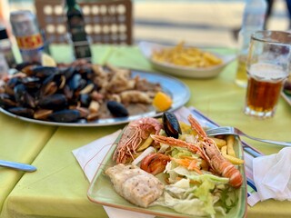 Grilled shrimps and mussels with salad on a plate. Tasty seafood salad with shrimps and mussels on...