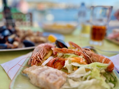 Grilled shrimps and mussels with salad on a plate. Tasty seafood salad with shrimps and mussels on the table