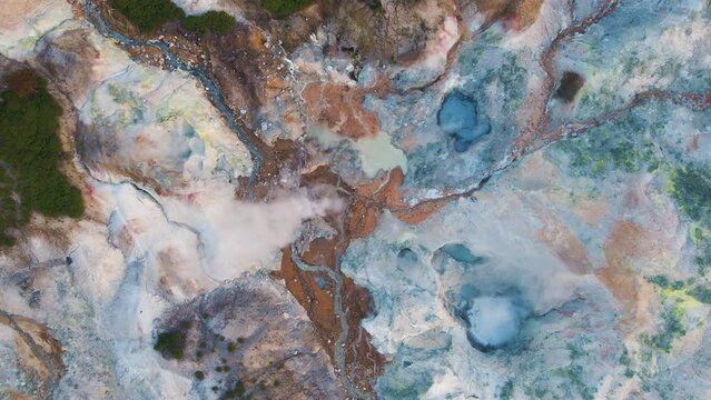 Cinematic aerial shot of geothermal steam vents in Jigokudani Hell Valley in Noboribetsu city in Hokkaido, Japan