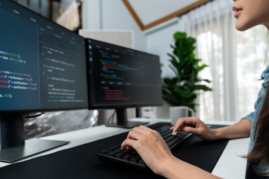 Young Asian in IT developer creating with typing online information on pc with coding program data of website application, wearing jeans shirt. surrounded by safety analysis two screens. Stratagem.