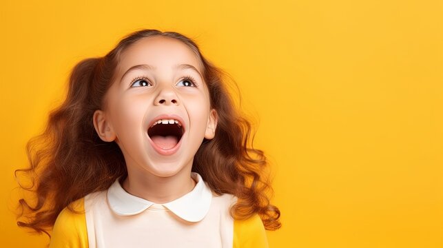 Portrait of happy excited amazed open mouth kid child girl look in copyspace isolated on yellow color background
