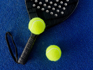 Pala de pádel con una pelota para jugar el deporte de mayor crecimiento en los últimos años a nivel mundial. Cancha de pádel en verano, el momento perfecto para practicar esta disciplina deportiva.