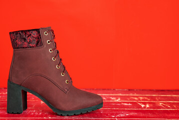 red of suede women's half-boots with high heels on a red background.