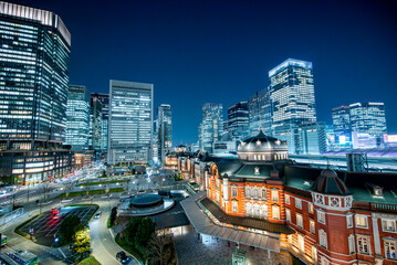 ライトアップされた夜の東京駅と高層ビル
