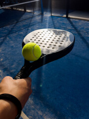 Pala de pádel con una pelota para jugar el deporte de mayor crecimiento en los últimos años a nivel mundial. Cancha de pádel en verano, el momento perfecto para practicar esta disciplina deportiva.