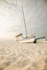 Boat on white sand on the sea coast at sunset.Sea transport. Sandy white dunes.Beach summer...