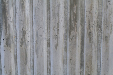 Abstract concrete striped of stone texture wall. Ribbed concrete background close-up, building material. Streaks like waves on a concrete wall.