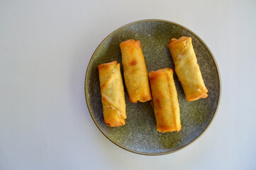 Delicious cheeseburger spring rolls on a plate in the kitchen.
