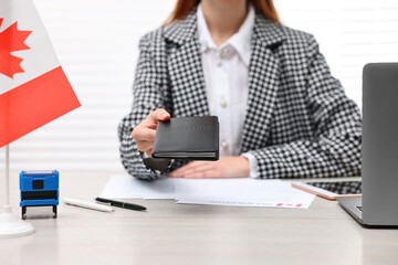 Immigration to Canada. Embassy worker with passport and documents at table in office, closeup