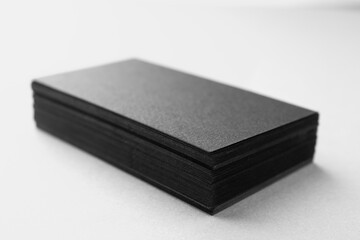 Blank black business cards on white table, closeup