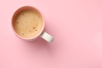 Aromatic coffee in cup on pink background, top view. Space for text