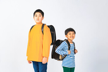 ランドセルを背負って並ぶ小学生の兄弟