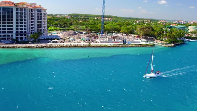 Aerial: Drone Panning Shot Of People Sailing Yacht In Blue Sea By Hotel Building In City On Sunny Day - Miami, Florida