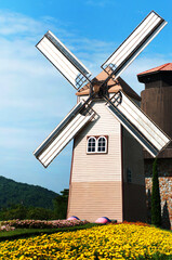 Wooden windmill on blue sky background