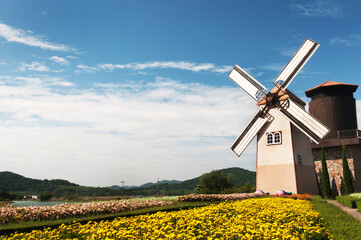 Wooden windmill on blue sky background