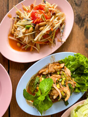 Spicy papaya salad or Somtum in Thai language serving on the table