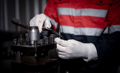 Industry engineer wearing safety uniform used vernier caliper to measure the object control...
