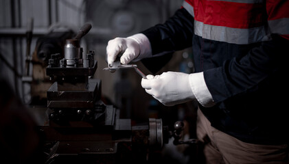 Industry engineer wearing safety uniform used vernier caliper to measure the object control...