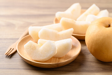 Piece of Asian pear fruit or Nashi pear on wooden bowl ready to eating