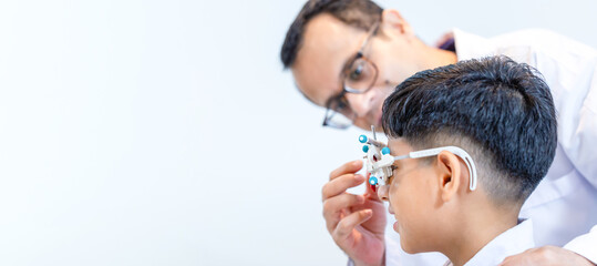 Indian-thai boy choosing glasses in optics store, Boy doing eye test checking examination with...