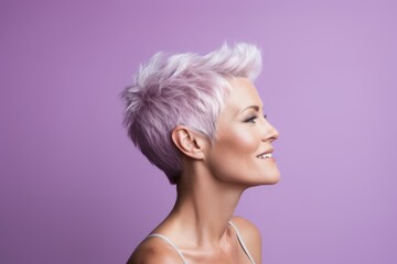 Portrait of a beautiful young woman with short pink hair on purple background