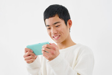 スマートフォンで動画を見る男の子　白背景