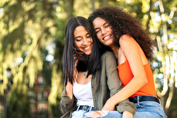 two young women couple sitting hugging and smiling. lesbian couple