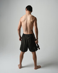 Full length portrait of fit handsome shirtless asian male model,  Holding viking axe weapon,...
