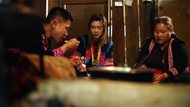 Asian Family Cooking And Having Dinner Together At Home. Hill Tribe Man And Woman In Traditional Dress Eating Food With Herbal Vegetable In Traditional Kitchen. Tribal Culture And Nature Food Concept.