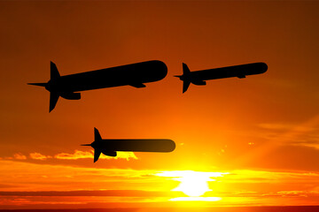 Silhouettes of Tomahawk cruise missiles against the sunset