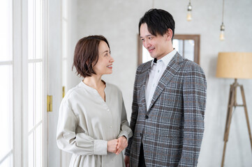 おしゃれな部屋にいるジャケットを着た男性とワンピースを着た女性