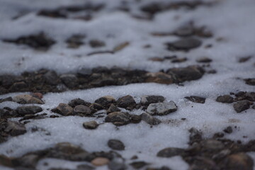 Pebbles on snow, grey lighting, macro