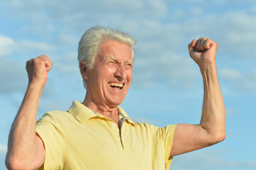Naklejka premium Senior man posing on blue sky background