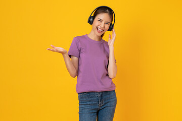 Cheerful young Asian woman in headphones listening to music and enjoy favourites playlist...
