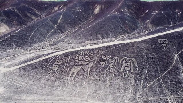 Aerial view of mysterious humanoid creatures and the Nazca lines in the peruvian desert.