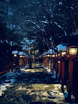 The road to the snow-covered torill (shrine gate) and red lantern box at Kifune Shrine at Kyoto, Japan at winter night