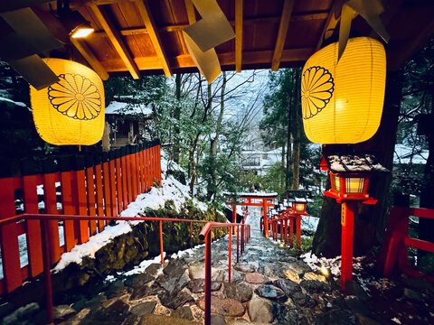 The snow-covered torill (shrine gate) and red lantern box at Kifune Shrine at Kyoto, Japan at winter night 