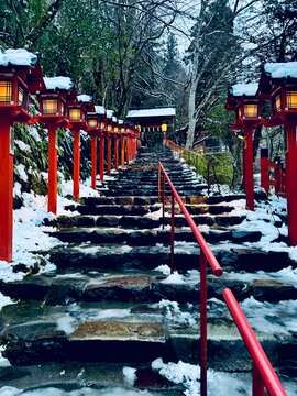 The road to the snow-covered torill (shrine gate) and red lantern box at Kifune Shrine at Kyoto, Japan at winter night 