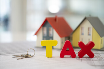 estate tax and inheritance tax concept. Tax word on wood block with house and property transfer...