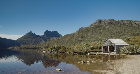 the old boat shed at dove lake with cradle mt in the distance on a calm summer morning at cradle...