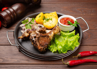Lamb with boiled potatoes. On a wooden background.