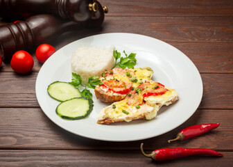 Chicken steak and boiled rice. On a wooden background.
