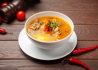 Shurpa soup with beef. On a wooden background.