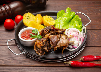Lamb ribs with boiled potatoes. On a wooden background.