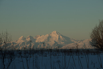 snowy mountain with sunrise shadows