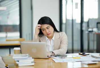 Female employees are stressed and tired. Headache from thinking and pressure from work.