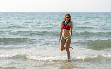 Portrait of smiling fashion woman relaxation on the tropical beach.Happy young beautiful girl enjoying and having fun on the tropical island.Summer vacation and travel